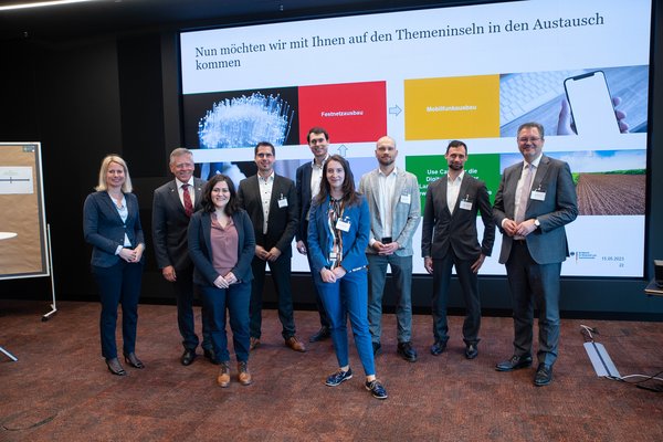 Eine Gruppe von Menschen steht vor einem großen Bildschirm